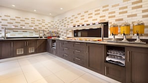 Une cuisine moderne avec des meubles en bois foncé, un pare-feu en carreaux et un bar pour prendre le petit-déjeuner.