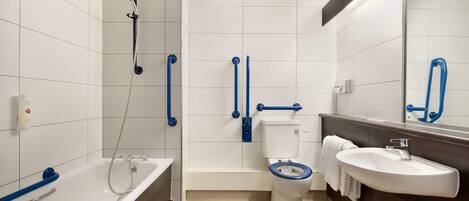 Un baño moderno con bañera, inodoro y lavamanos, equipado con barras de apoyo y ducha.