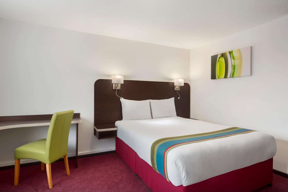 Een hotelkamer met een bed, een bureau en een stoel.