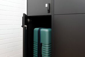 Secure storage for your belongings, featuring a compact cabinet with a lock and a suitcase with a zipper and handle.