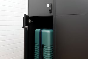 Secure storage for your belongings, featuring a compact cabinet with a lock and a suitcase with a zipper and handle.