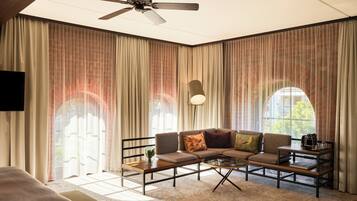 Ein modernes Wohnzimmer mit einem Ecksofa, einem Couchtisch und einem Deckenventilator.