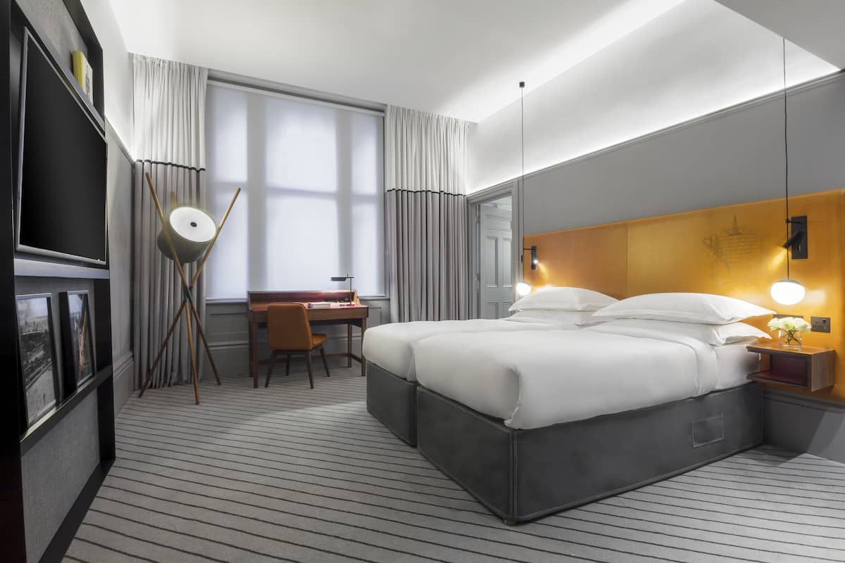 Een moderne hotelkamer met een groot bed, een bureau en een flatscreen televisie.