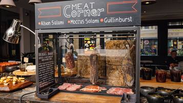 Mostrador de carnes con diversas opciones de carne y condimentos, incluyendo un letrero que dice 'Meat Corner' con nombres como Albion Salami, Moccus Salami y Guillinburst.