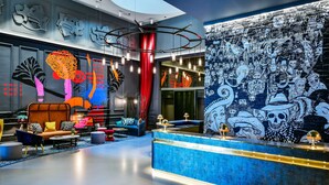 A modern lobby with a blue reception desk, comfortable seating, and a large mural on the wall. - ANDAZ LONDON LIVERPOOL STREET, BY HYATT (London)