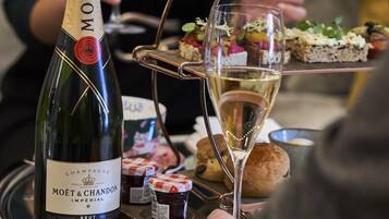A bottle of Moët & Chandon champagne, a glass of champagne, and a tray with assorted appetizers.