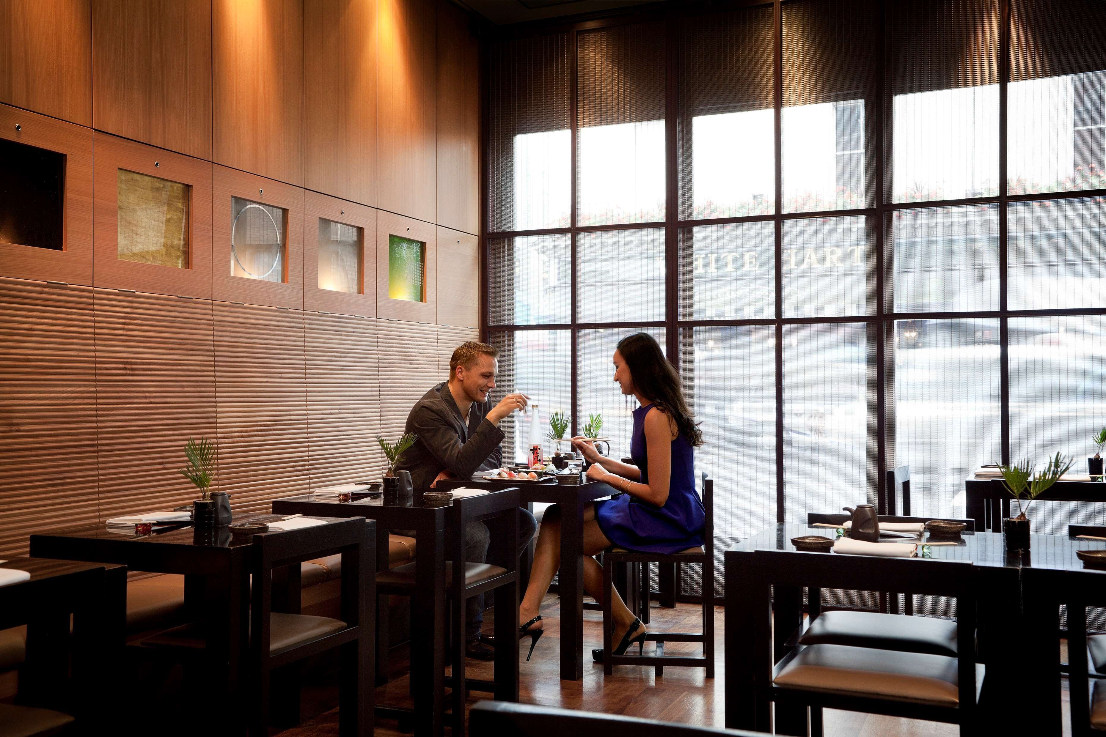 A restaurant with wooden paneling and large windows.