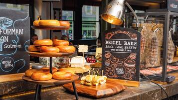 Mostrador de panadería con diversos productos horneados y un cartel que dice 'Beige Bake Brick Lane Bakery'.