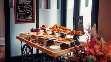A bakery display with various pastries and a chalkboard menu listing items like chocolate cake and croissants.