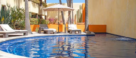 Una piscina al aire libre, sombrillas, tumbonas