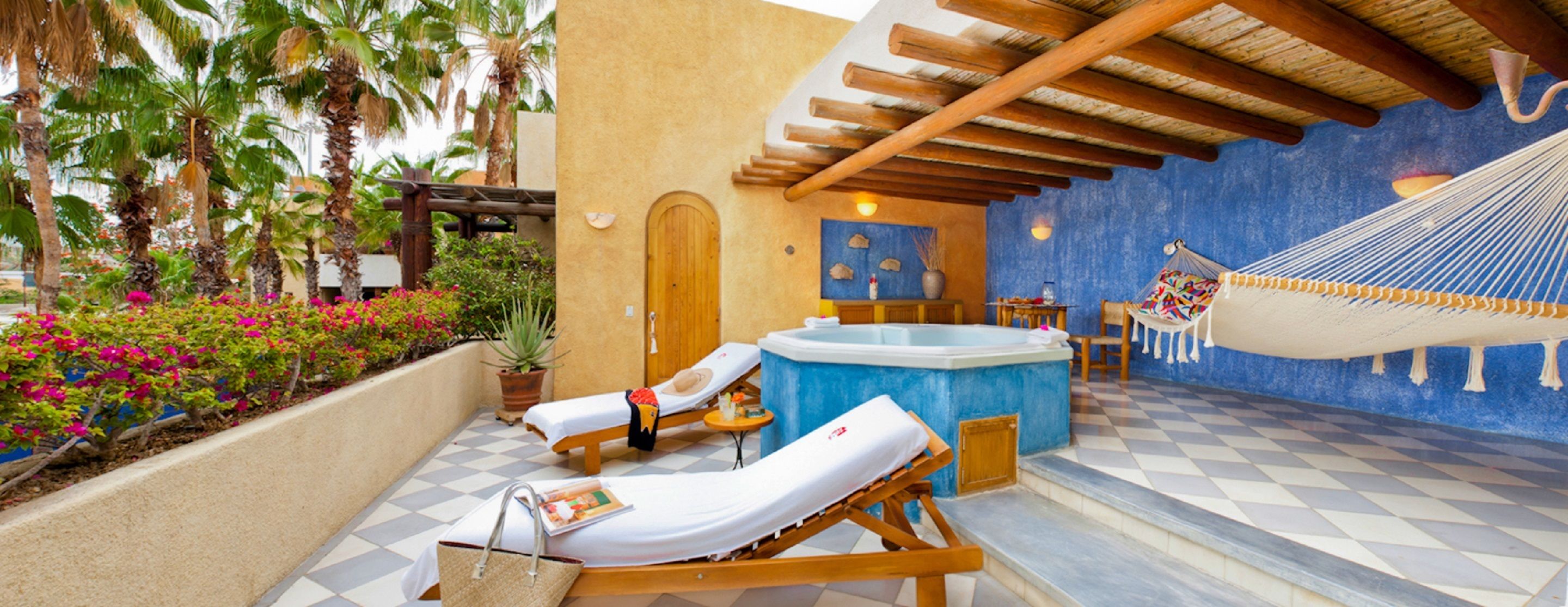 Uma área de spa com duas espreguiçadeiras, uma banheira de hidromassagem e um balanço.