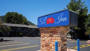 Un letrero del SLO Inn, con base de piedra y fondo azul.