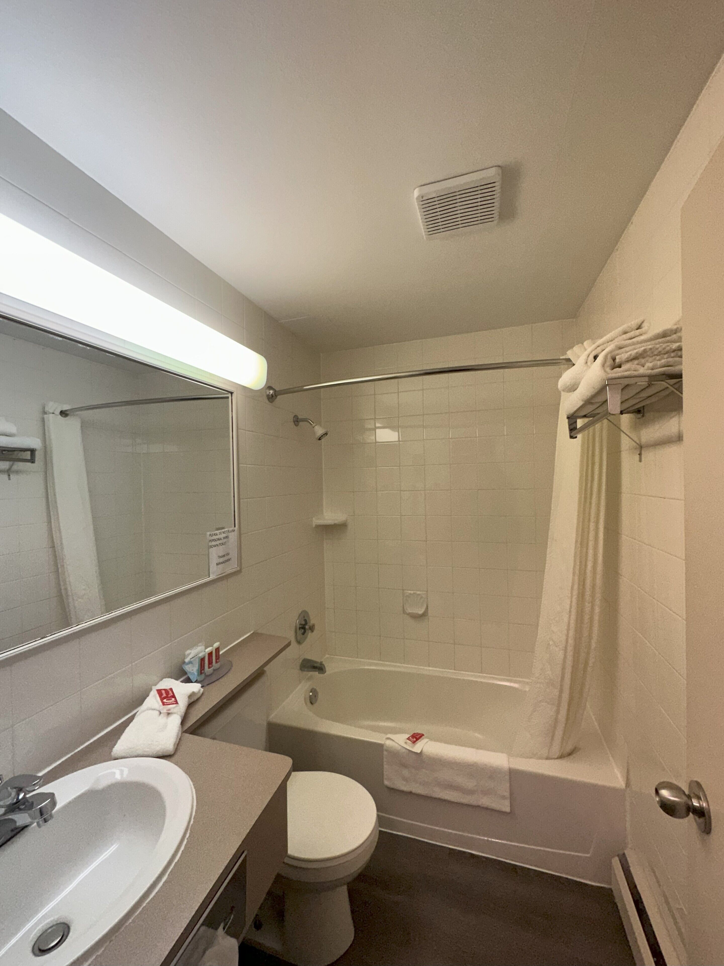 Un baño con bañera, inodoro, lavabo y espejo.