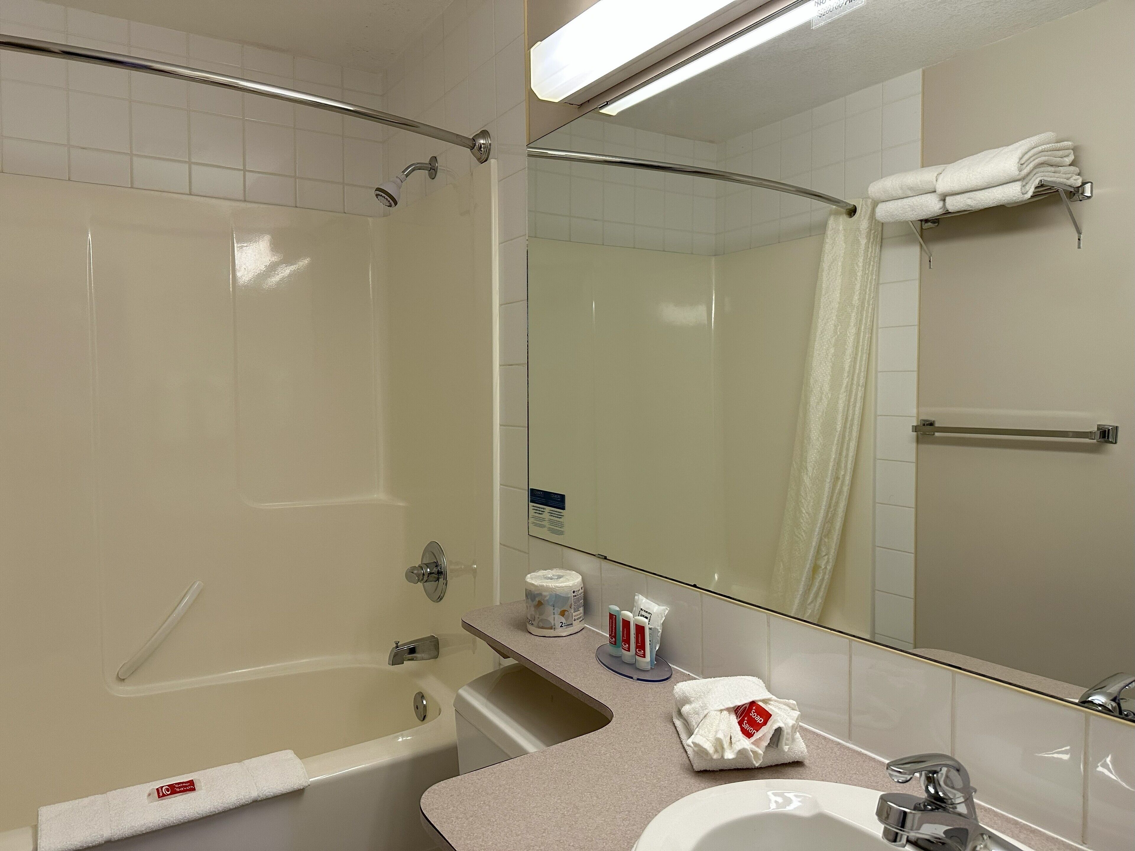 A modern bathroom with a bathtub, a shower, a sink, and a mirror.