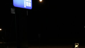 Señal de Relax Inn iluminada en azul contra un cielo nocturno oscuro.