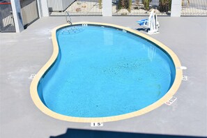 Una piscina al aire libre de temporada, sombrillas