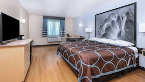 A hotel room with a bed, a desk with a computer, a television, and a large window with curtains. - Super 8 by Wyndham New Braunfels I-35 (New Braunfels)