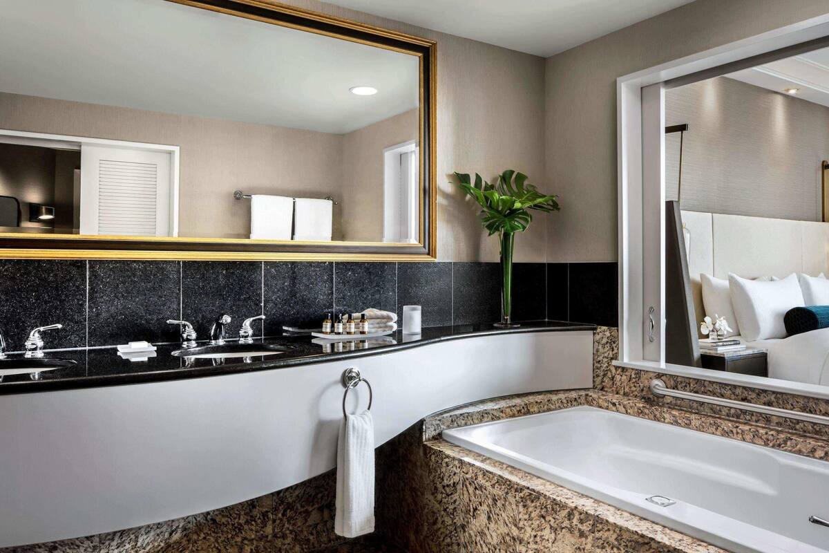Een aparte badkuip en douche, een diep bad, designer toiletartikelen