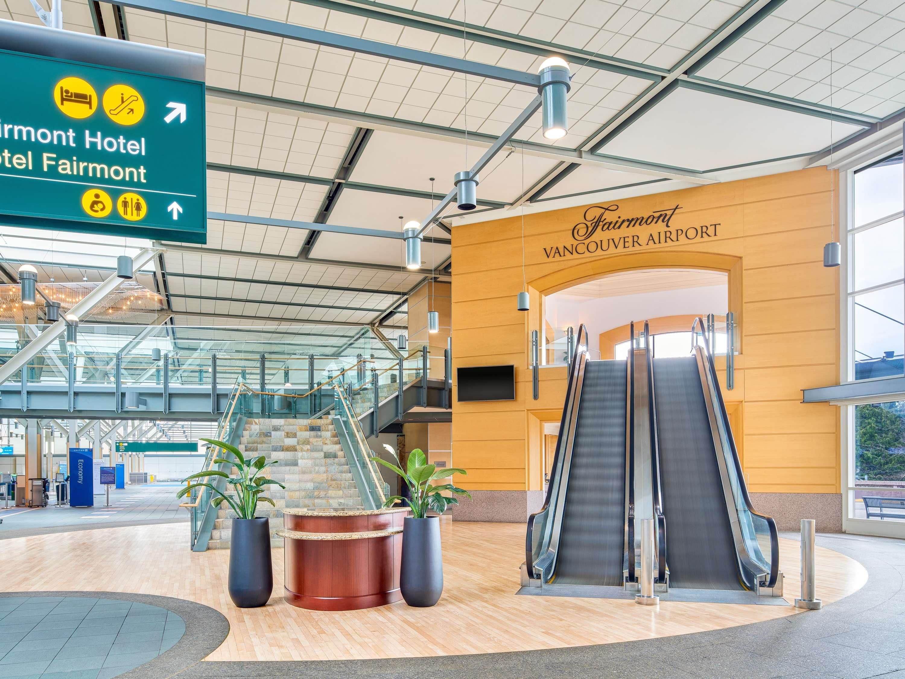 A modern airport terminal with a sign for Fairmont Hotel and Fairmont Vancouver Airport.