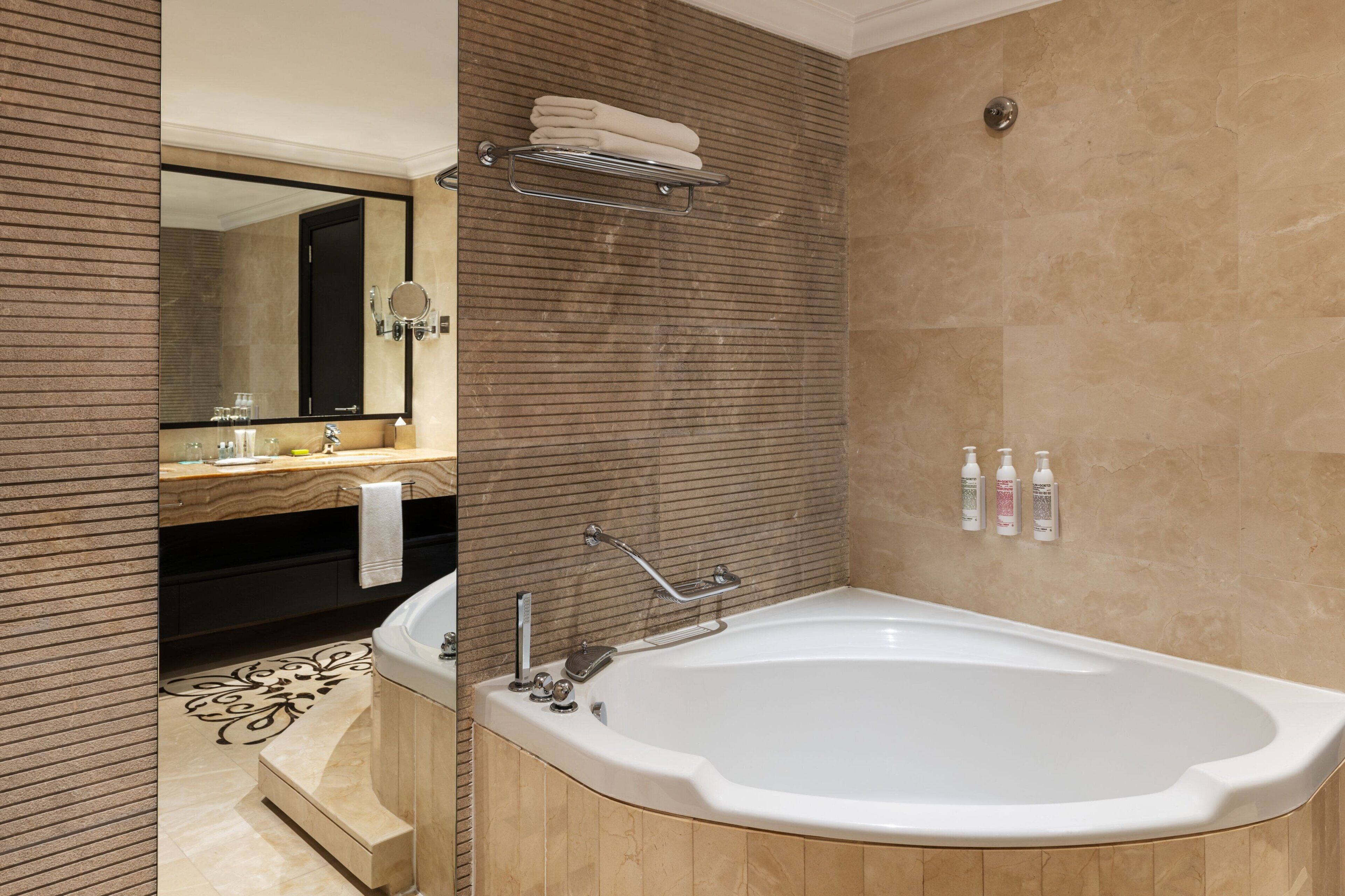 A modern bathroom with a freestanding bathtub, a vanity with a mirror, and a towel rack.