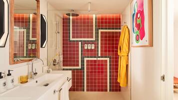 A bathroom with a white sink, mirror, and a shower area.