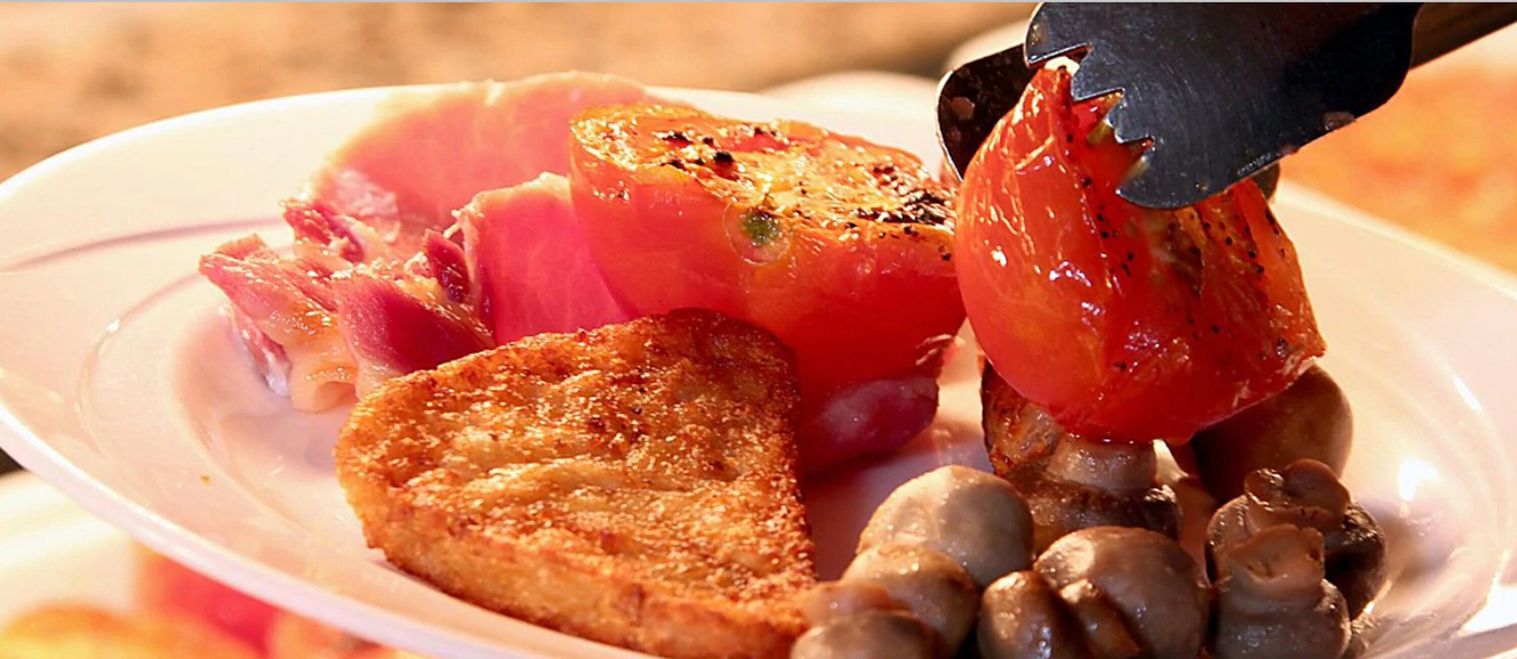 A plate with grilled meat, a slice of bread, and some mushrooms.