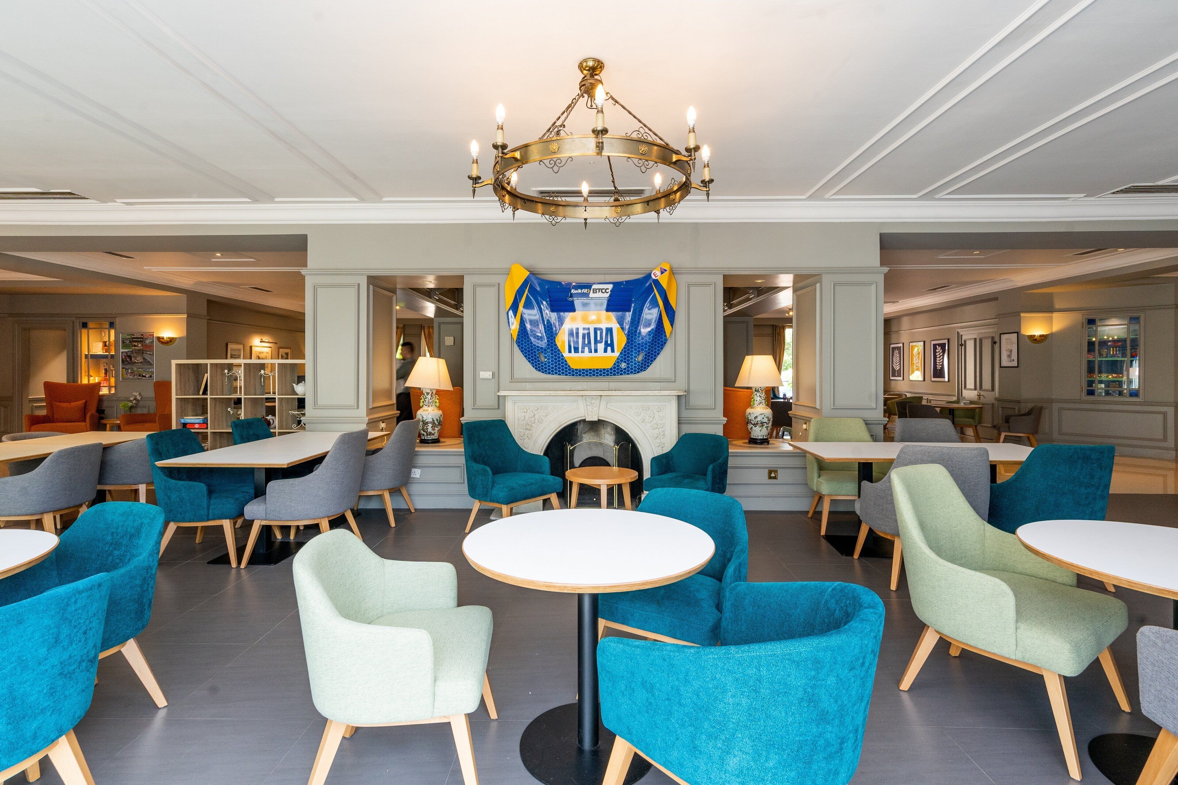 A spacious lobby with round tables and chairs, a chandelier, and a banner with the text "NAPA".