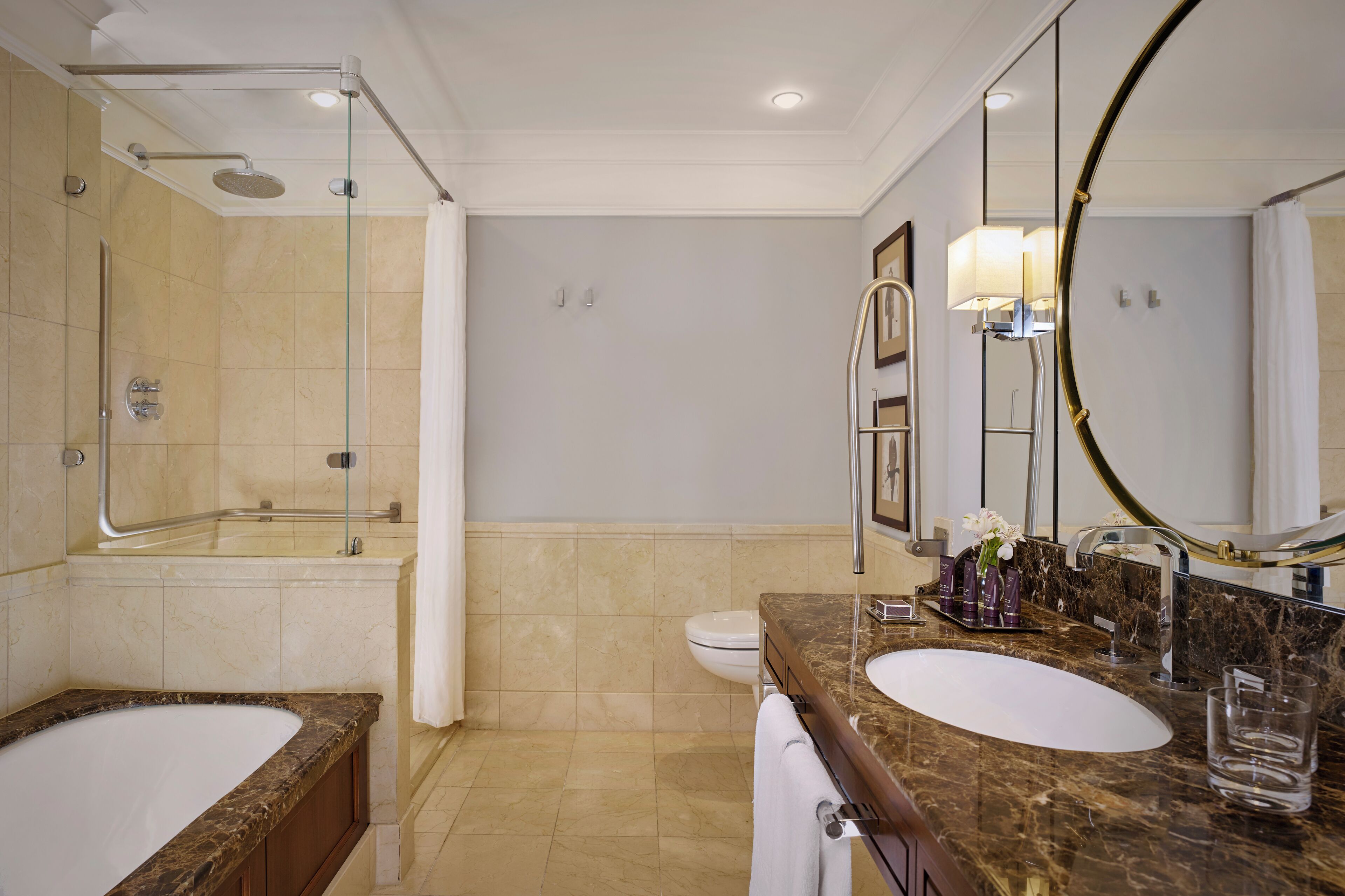A modern bathroom with a double sink, a bathtub, a shower, and a large mirror.