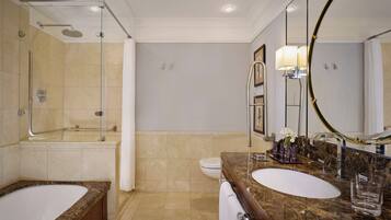 A modern bathroom with a double sink, a bathtub, a shower, and a large mirror.