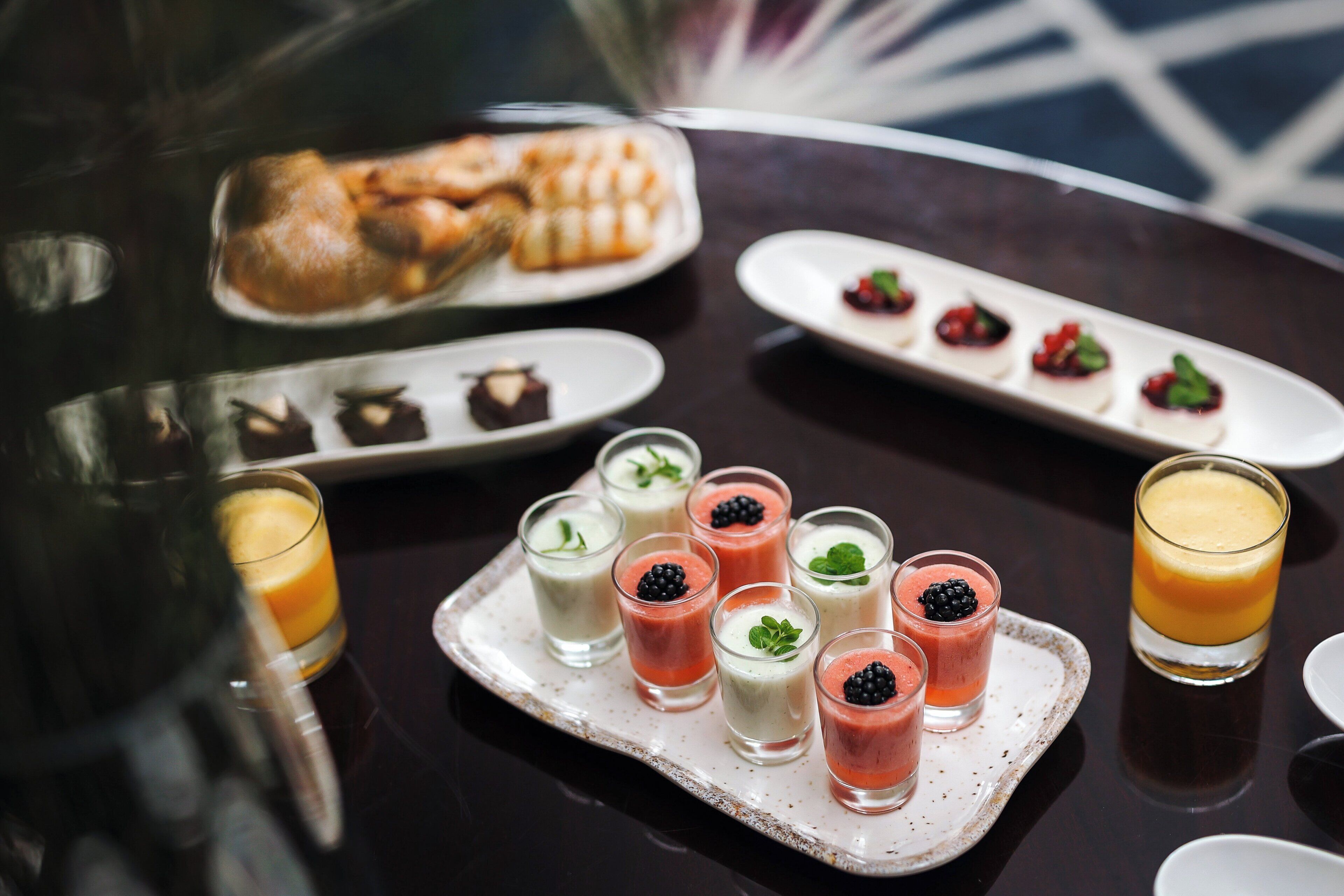 Una mesa de postres con diversos pasteles y bebidas.