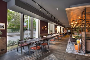 A restaurant with long tables, chairs, and a view of the outdoors.