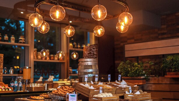 A bakery display with various baked goods and a wooden barrel. - Crowne Plaza Porto by IHG (Porto)