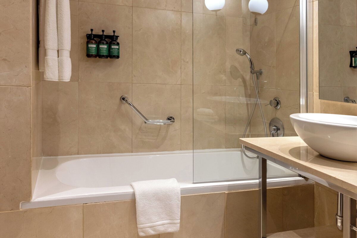 Un baño moderno con bañera, lavamanos y ducha.