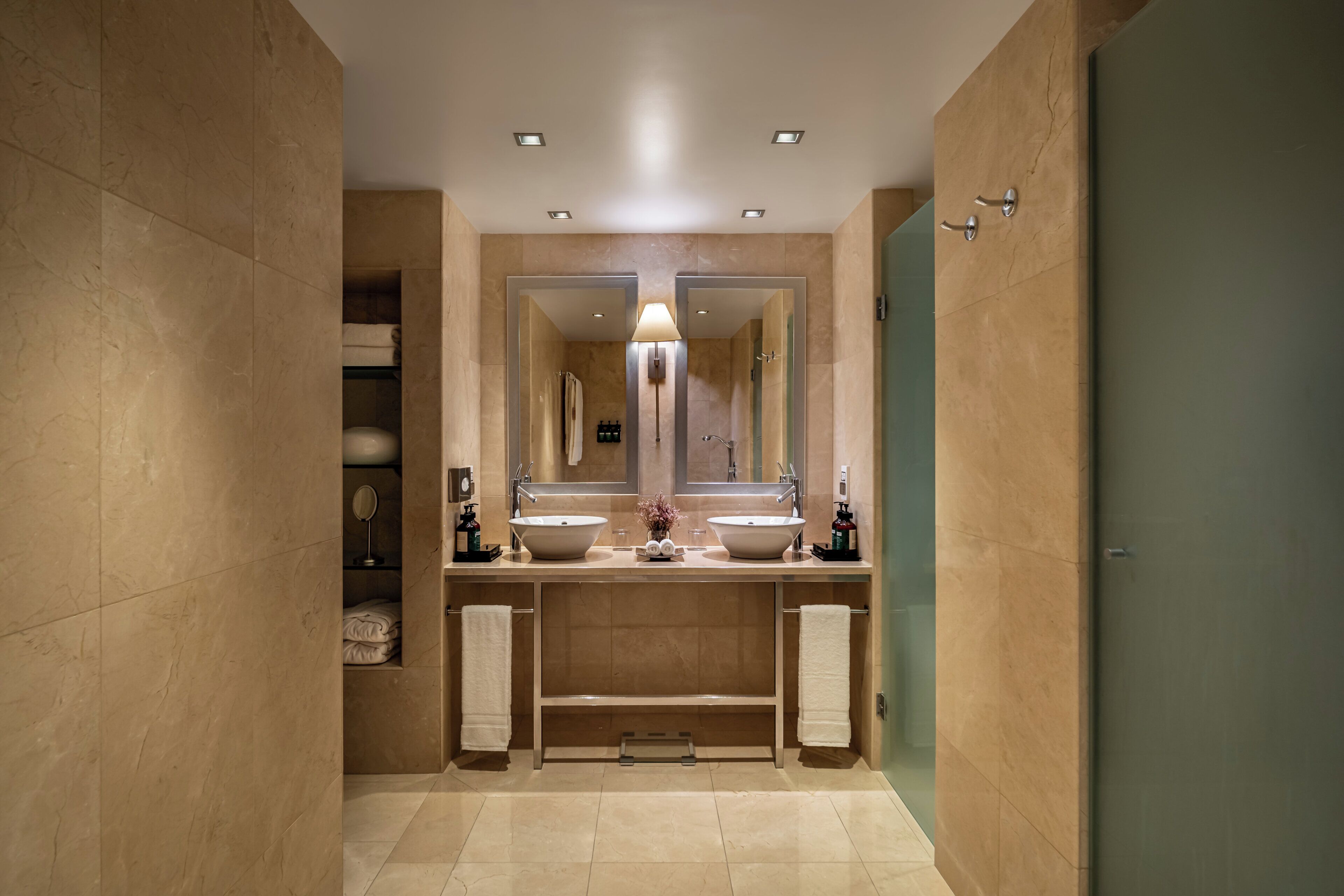 A bathroom with two sinks, a large mirror, and a towel rack.