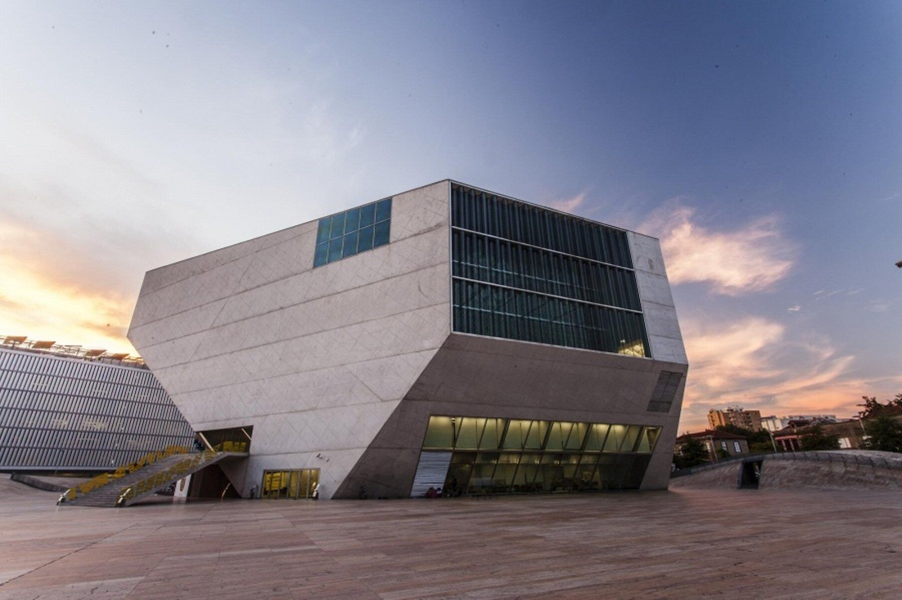 A modern building with a unique angular design, large glass windows, and a flat roof.