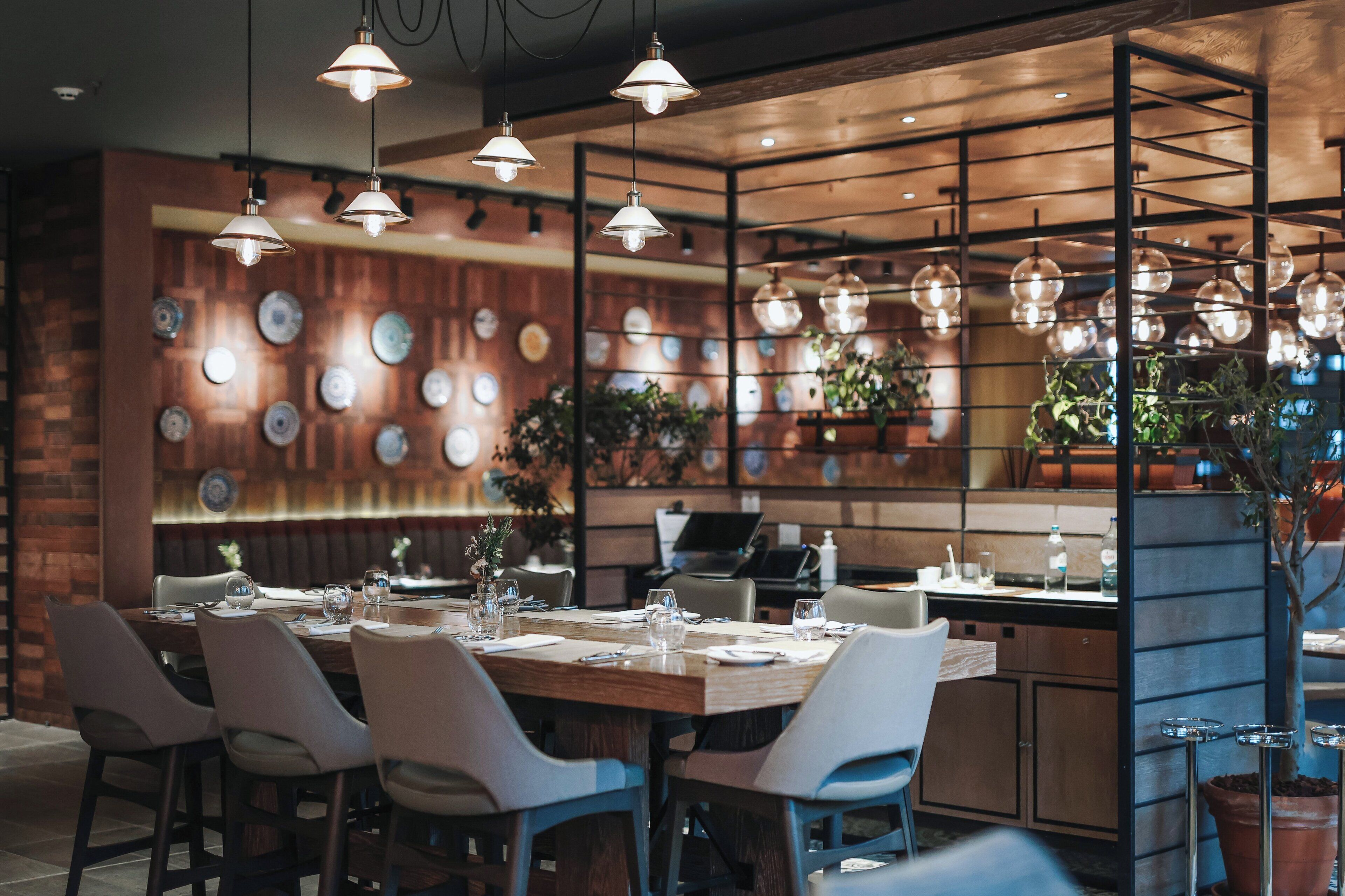Un restaurante con pared de madera, luces colgantes y una variedad de platos exhibidos.