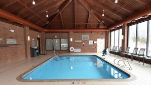 An indoor swimming pool with clear depth markers, a lifeguard station, and a seating area with chairs. - Fairfield Inn by Marriott Binghamton (Binghamton)