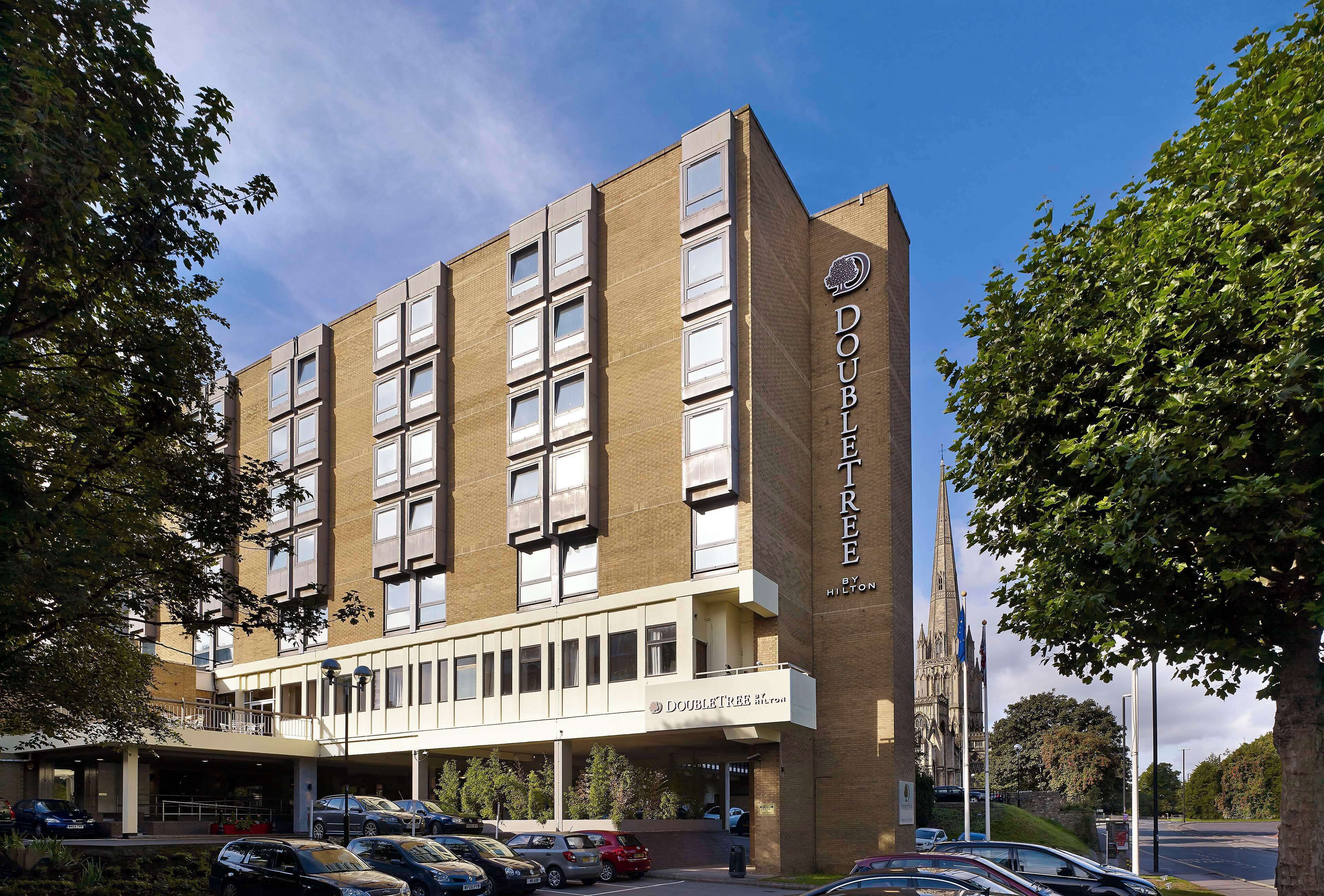 Ett hotell som heter ”DoubleTree by Hilton” med en modern design, flera våningar och en framträdande entré.