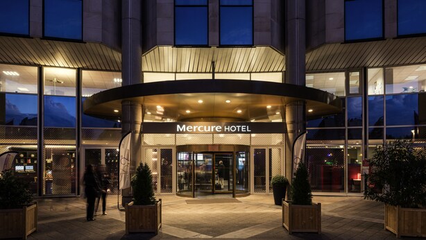 L'esterno dell'Hotel Mercure, dal design moderno, con ampie vetrate e un ingresso ben visibile.