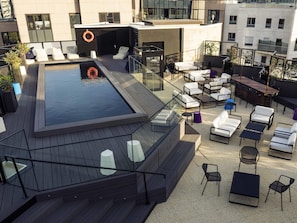 A rooftop terrace with a pool, outdoor seating, and a lifebuoy. - Mercure Paris Boulogne (Boulogne-Billancourt)