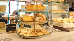 Une vitrine de boulangerie présentant diverses pâtisseries et gâteaux, dont un panneau indiquant la présence de gâteau au citron.