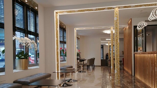 Un lobby moderno con asientos, una recepción y un piso con diseño.