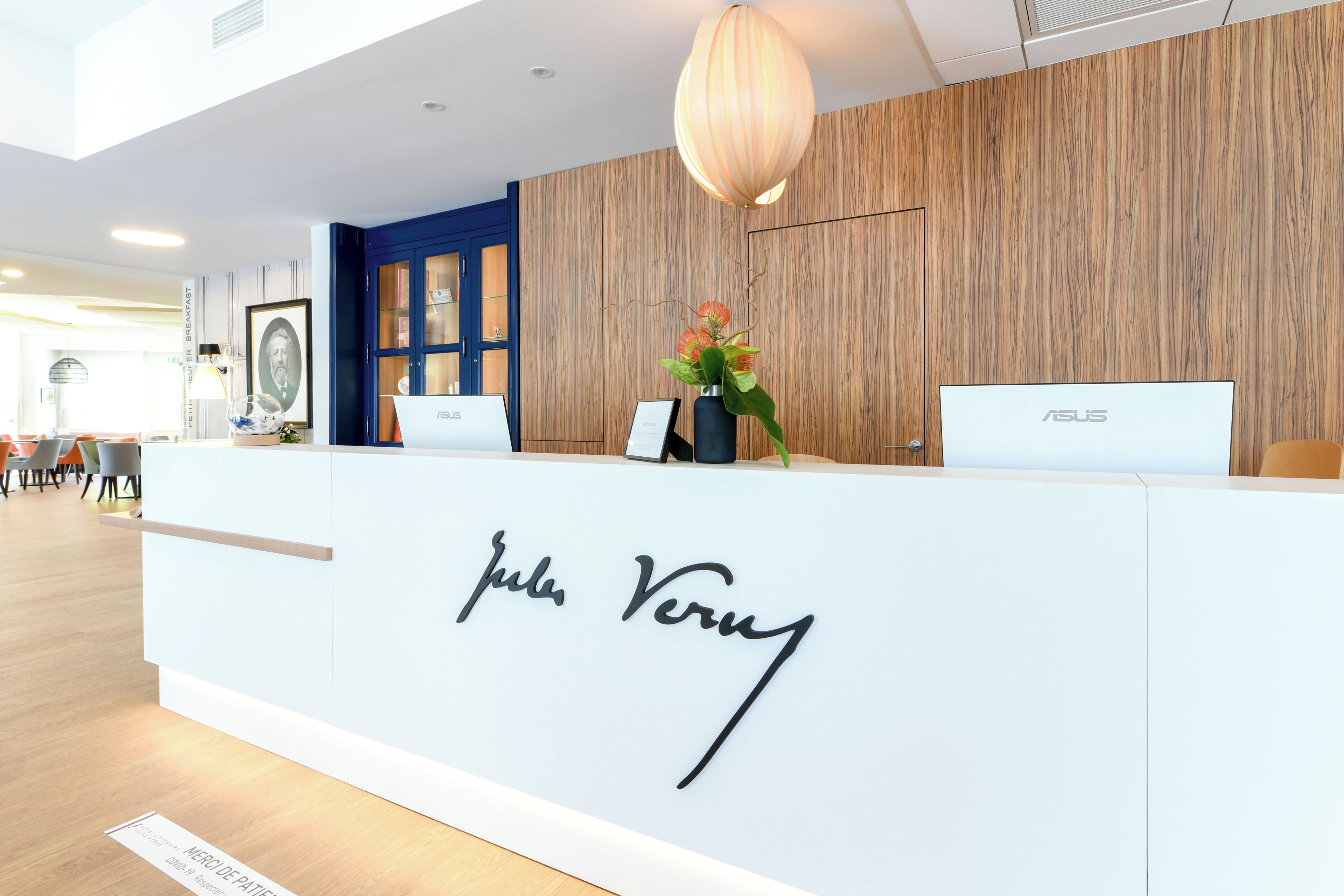 A reception desk with a sign that reads 'Jul Ver' and two laptops.