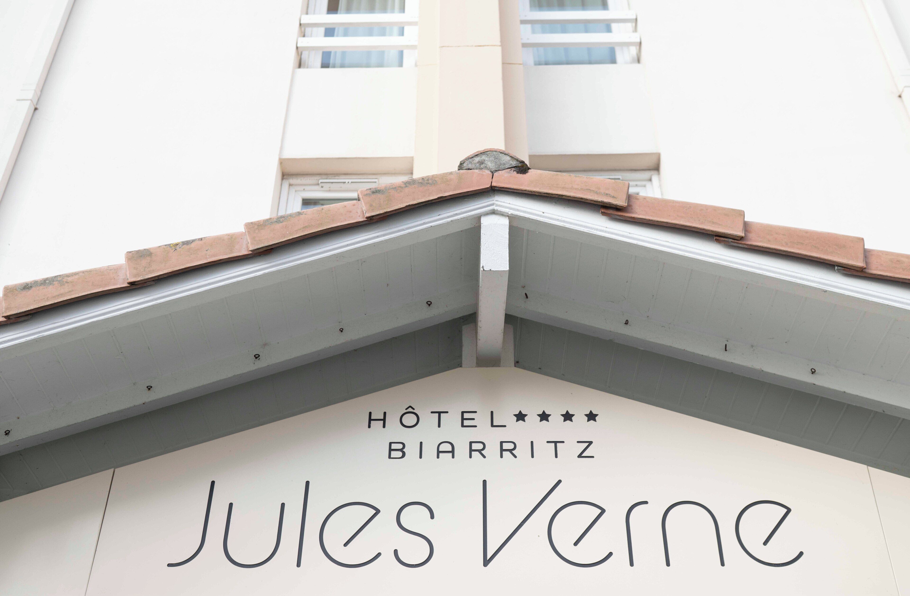 A hotel entrance with a sign reading 'Hôtel BIARRITZ Jules Verne'.
