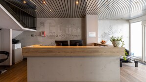 Una recepción de diseño moderno, una escalera y una pared con varios dibujos técnicos.