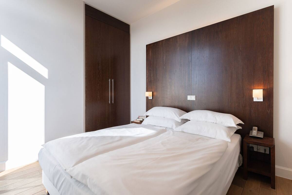 Hypo-allergenic bedding, desk, laptop workspace, blackout drapes