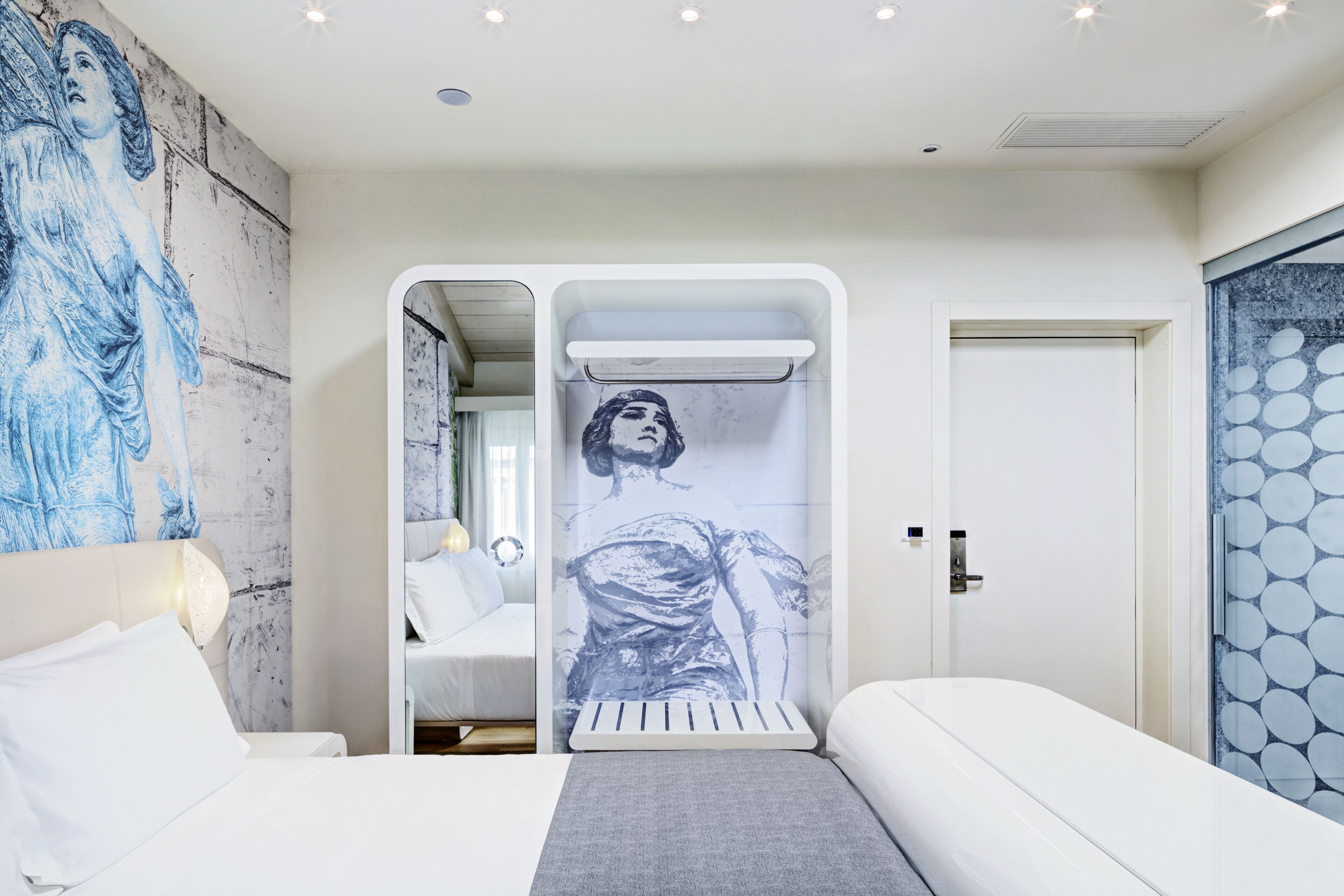 Ein modernes Schlafzimmer mit einem großen Bett, einem Nachttisch, einem Wandradiator und einer Tür mit einem runden Muster.