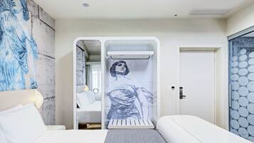 Ein modernes Schlafzimmer mit einem großen Bett, einem Nachttisch, einem Wandradiator und einer Tür mit einem runden Muster.