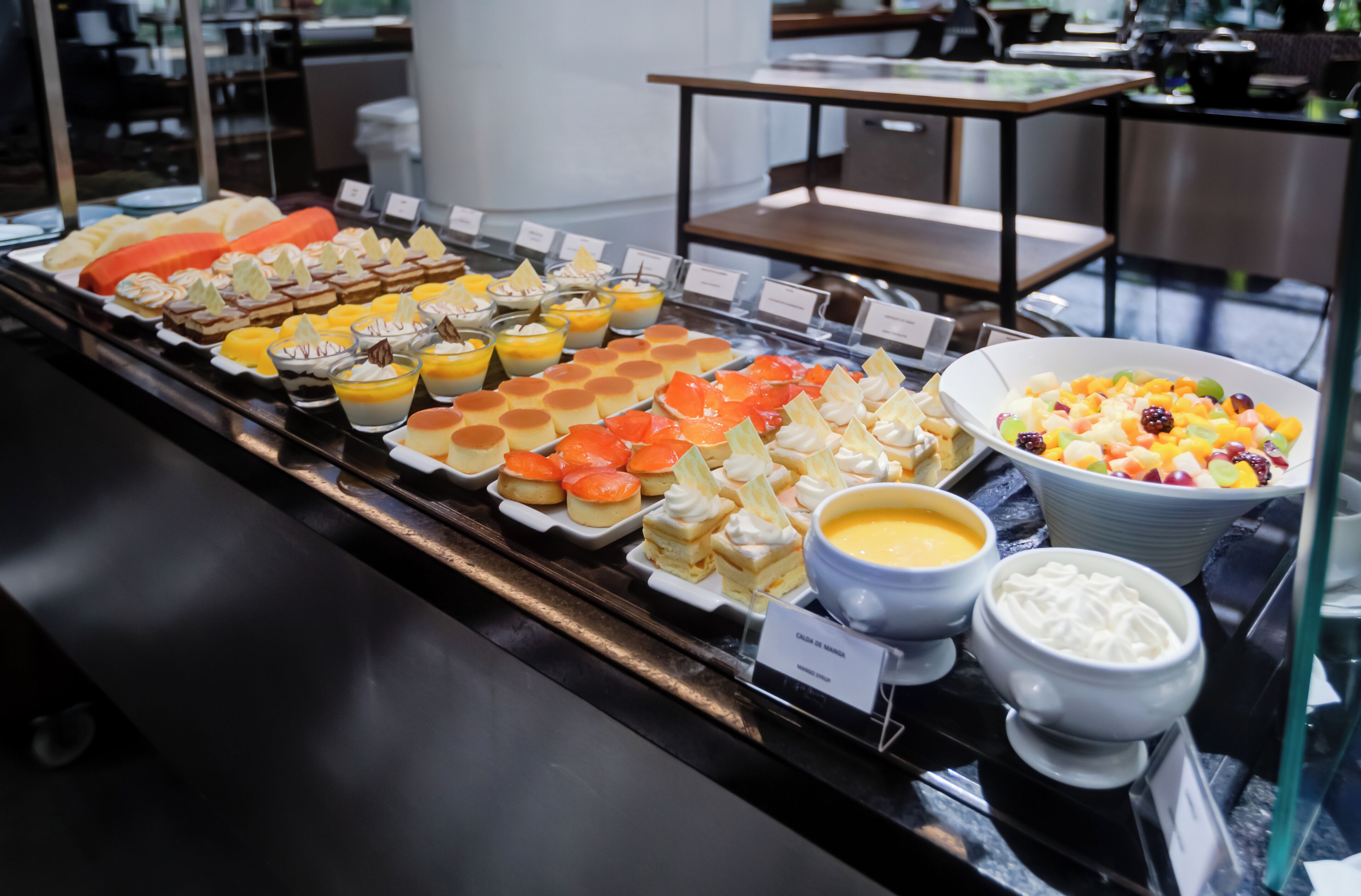 Un buffet con diverse pietanze, tra cui pasticcini, frutta e dolci.