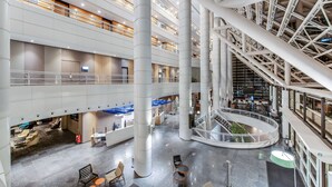 Un atrium à plusieurs niveaux, doté d’un escalier en colimaçon central, d’espaces de détente et d’un comptoir d’accueil.